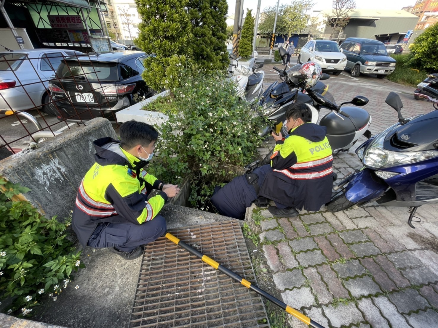 圖片說明：南崁所員警見民眾在水溝裡抓貓主動提供協助。（記者宋紹誠翻攝）