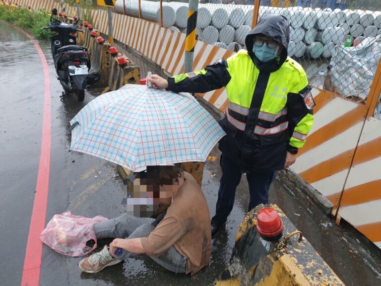 圖片說明：山佳派出所警員何洹、張育齊於滂沱大雨中救助一名車禍受傷民眾。(記者宋紹誠攝)