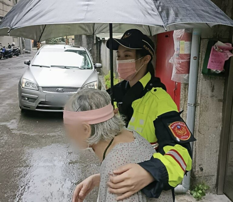 圖片說明：中和警撐傘帶老婦回家。（記者徐煜勝翻攝）