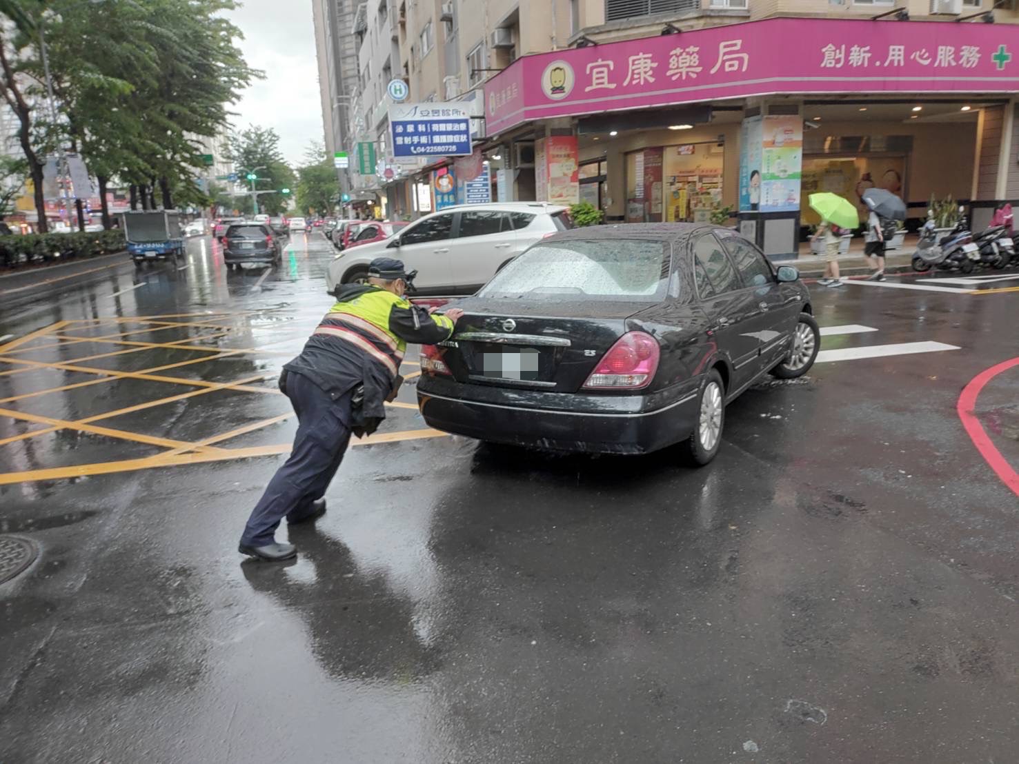 中市警四分局黎明派出所員警協助將拋錨車推往路旁。(圖/記者謝榮浤翻攝)