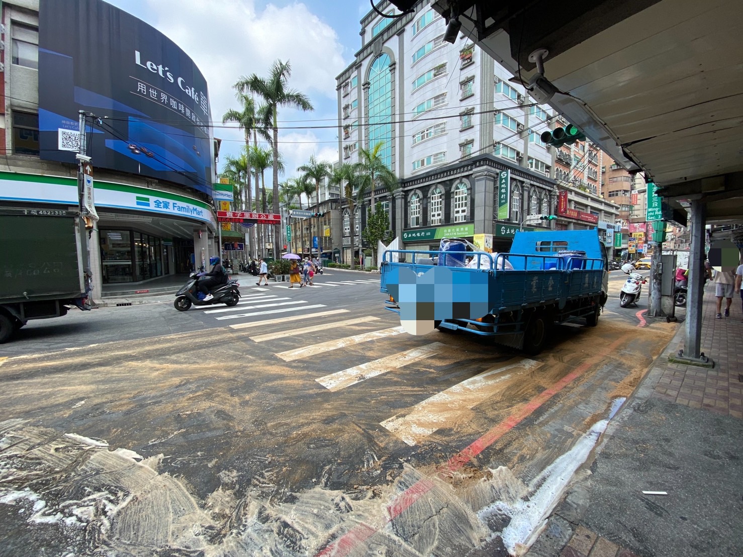 彭姓小貨車駕駛（男、66歲）發現車上裝載的潤滑油桶傾倒，隨即停車處理。然而，油漬已擴散至路面，導致接下來經過該處的4名騎士不幸摔車。（記者黃荷琇翻攝）