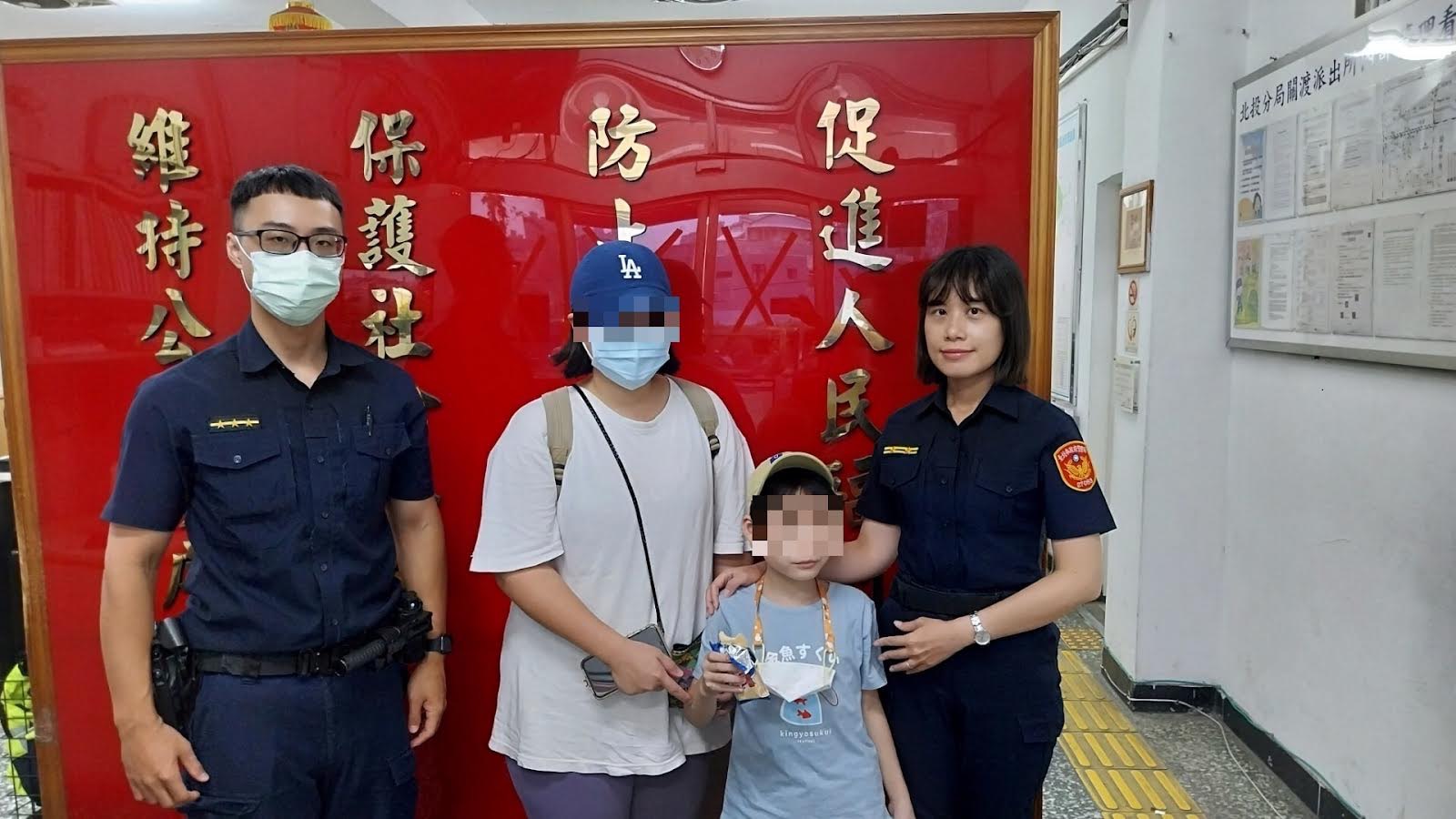 北投分局關渡派出所所長陳以雯及警員郭駿宏協助走失的男童與家人團聚。（記者薛秀蓮翻攝)