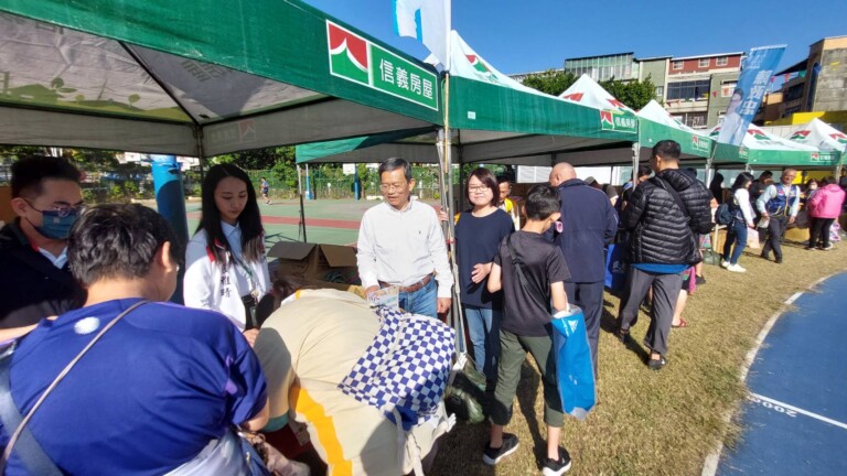 台北市議員陳政忠與北市社會局長姚淑文在現場協助發放物資給社子地收入戶居民。(記者張欽攝影)