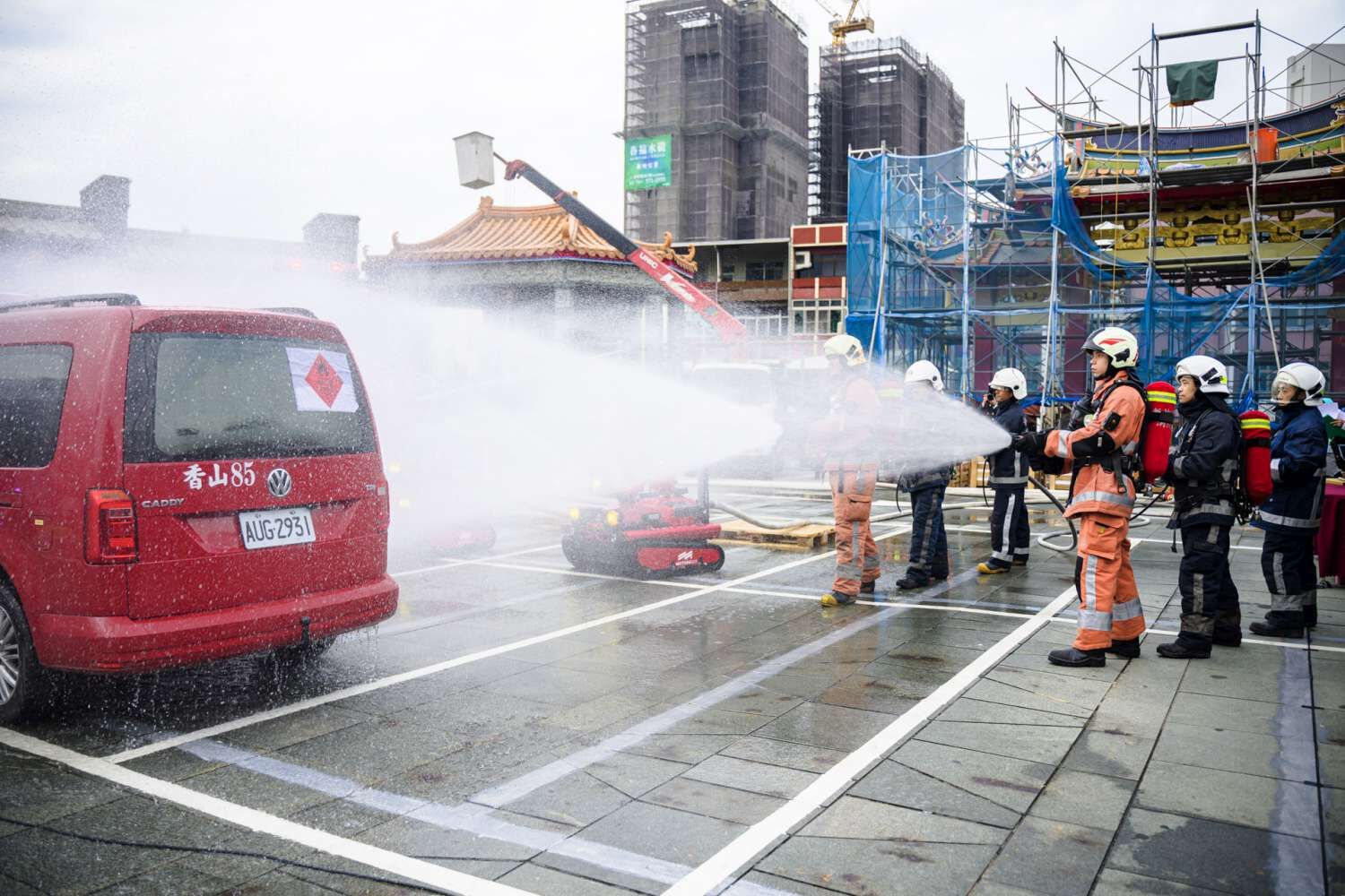 消防局與義消模擬易燃液體車輛火災，結合消防機器人與水線佈署，共同控制火勢，確保救援安全。（圖/記者林照東翻攝）