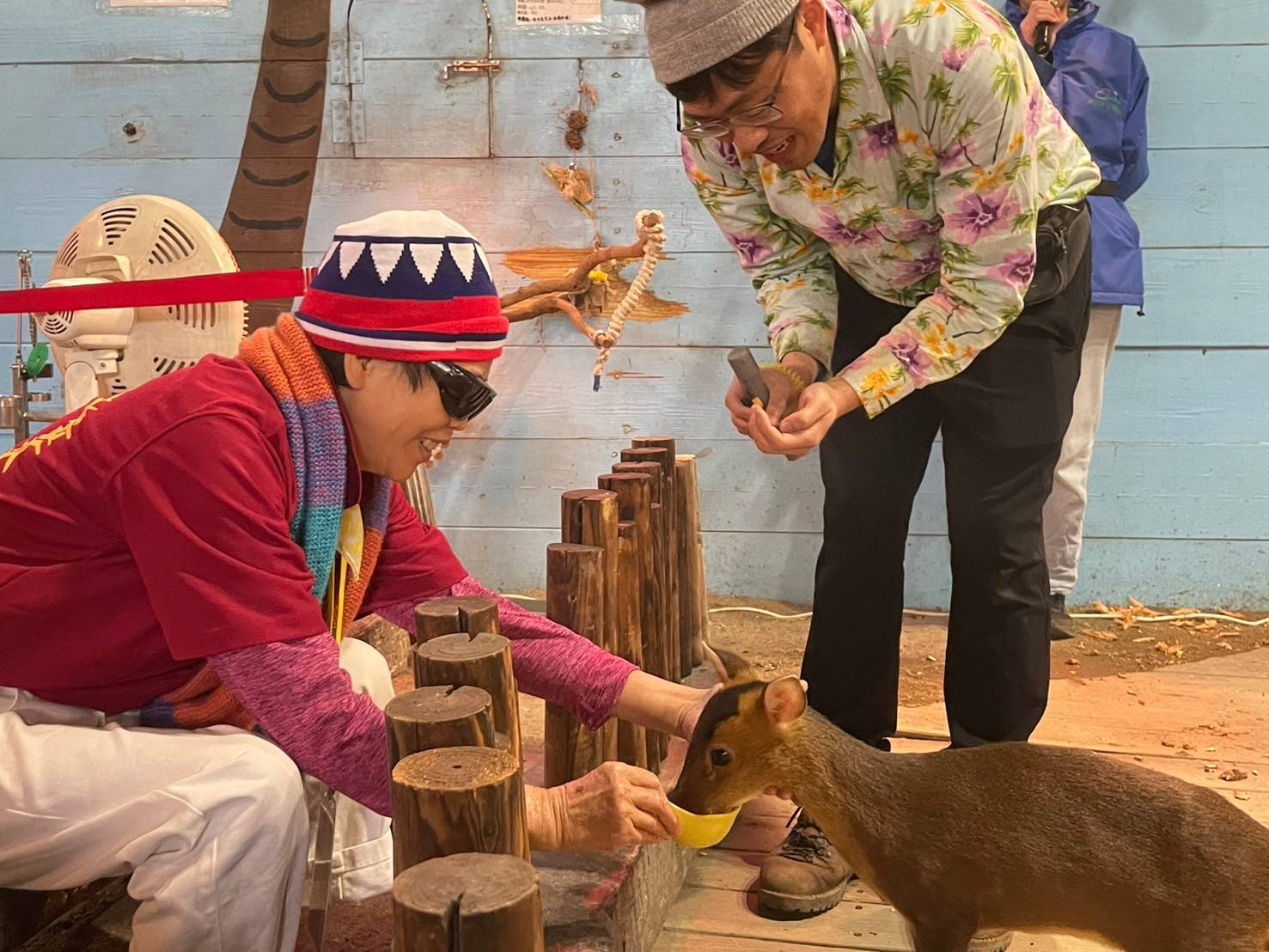 榮家住民李阿姨餵食小山羌，流露出與動物互動的喜悅。（圖/記者黃溎芬翻攝）