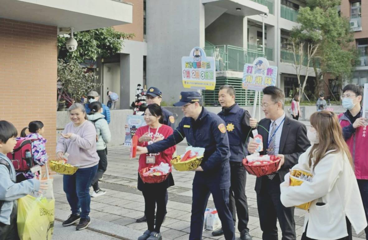 南港分局長周哲民率同仁至東新國小守護學童安全，並與東新國小校長李家旭共同發放新春小禮品給學童們。（記者薛秀蓮翻攝)