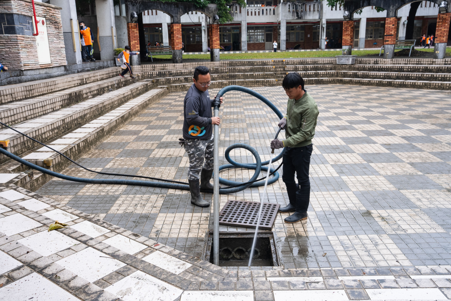 南投縣竹山鎮的前山國小校門遇雨即積水，遠雄志工為學童打造平坦校園路。(圖/ 遠雄文教公益基金會提供)